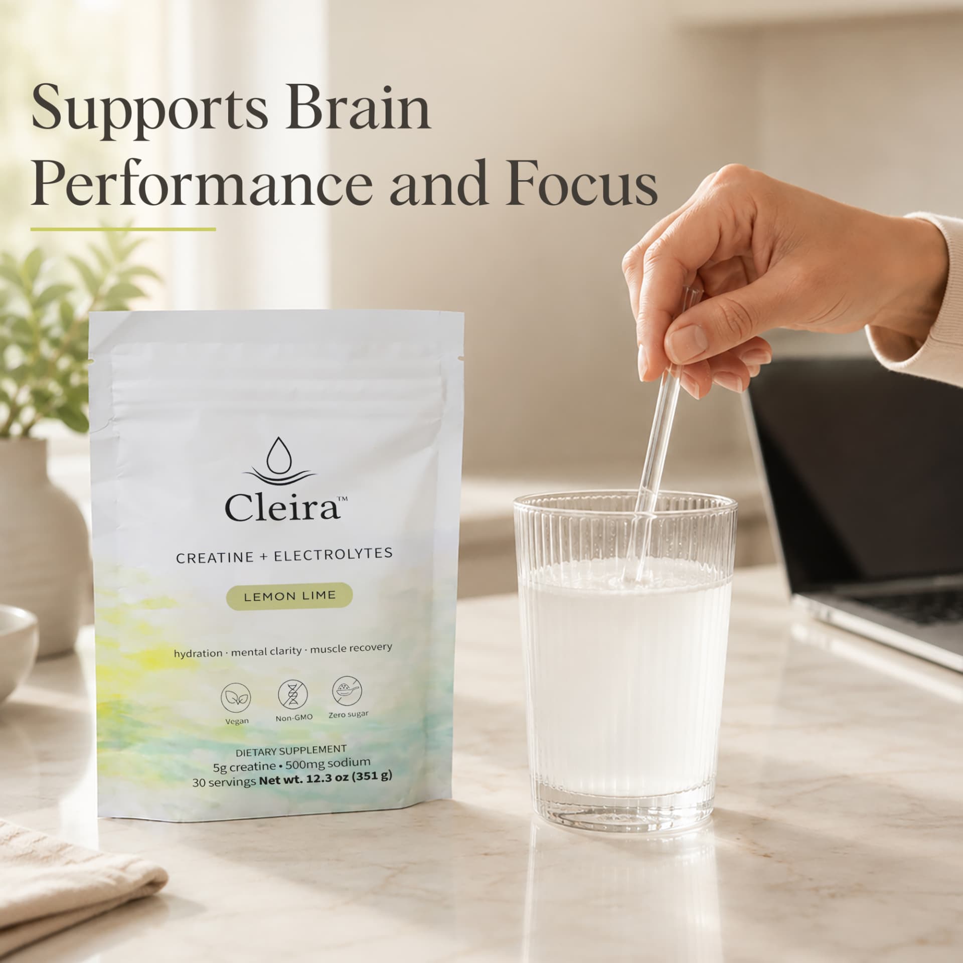 Cleira pouch beside a freshly stirred glass on a sunlit desk